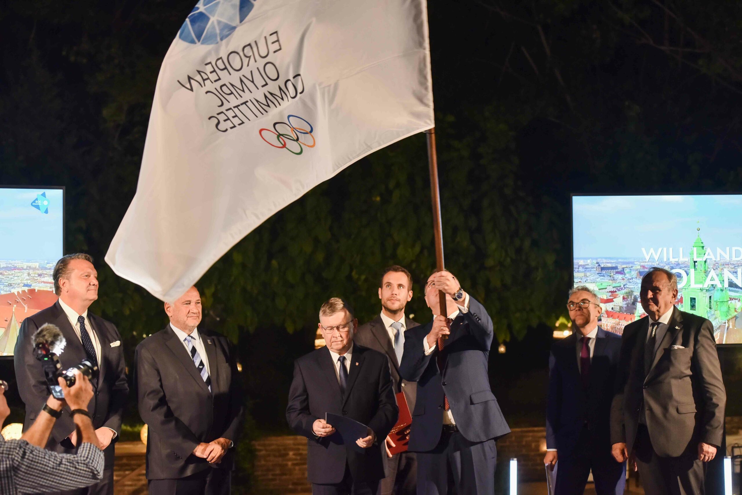 People holding European Olympic Committees Flag in a ceremony